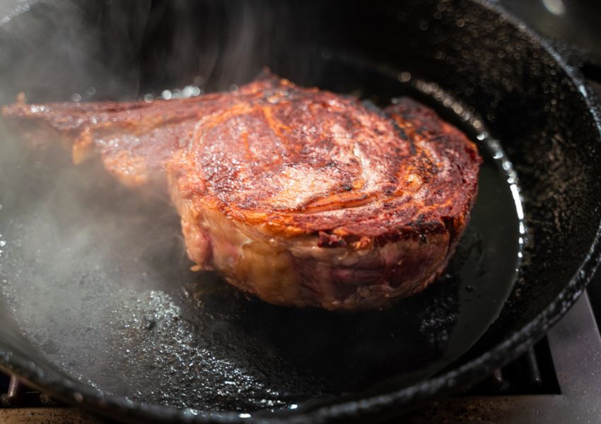 cast iron with steak cooking